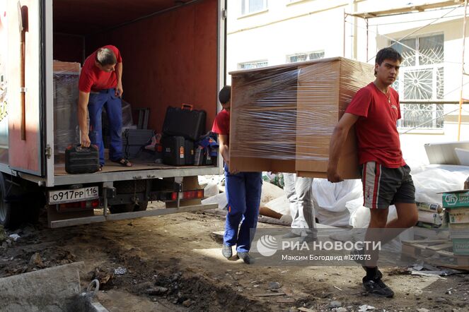 Рабочие жилищно-коммунальной службы разгружают новую мебель для учеников во дворе гимназии № 27 с татарским языком обучения. Место: Россия, Республика Татарстан, Казань. Автор: Максим Богодвид/РИА Новости. Подготовка школ к началу учебного года