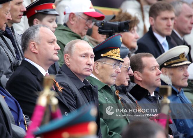 9 мая 2017. Президент РФ - Верховный главнокомандующий вооружёнными силами РФ Владимир Путин и председатель правительства РФ Дмитрий Медведев на военном параде в ознаменование 72-й годовщины Победы в Великой Отечественной войне 1941–1945 годов на Красной площади в Москве. Слева - президент Молдавии Игорь Додон. Место: Россия, Москва. Автор: Михаил Климентьев/РИА Новости. Президент РФ В.Путин и премьер-министр РФ Д.Медведев на военном параде в честь 72-й годовщины Победы в ВОВ
