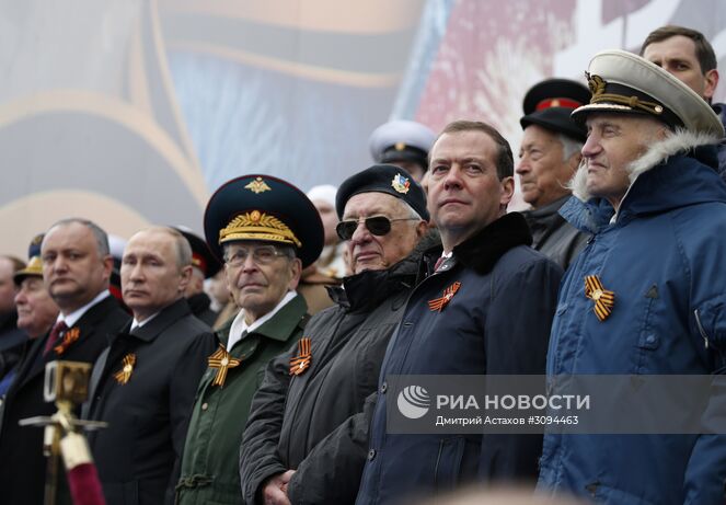 9 мая 2017. Президент РФ Владимир Путин и председатель правительства РФ Дмитрий Медведев во время военного парада в ознаменование 72-й годовщины Победы в Великой Отечественной войне 1941–1945 годов на Красной площади в Москве. Слева - президент Молдавии Игорь Додон, Место: Россия, Москва. Автор: Дмитрий Астахов/РИА Новости. Президент РФ В.Путин и премьер-министр РФ Д.Медведев на военном параде в честь 72-й годовщины Победы в ВОВ