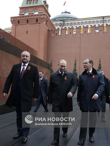9 мая 2017. Президент РФ Владимир Путин и председатель правительства РФ Дмитрий Медведев перед началом военного парада в ознаменование 72-й годовщины Победы в Великой Отечественной войне 1941–1945 годов на Красной площади в Москве. Слева - президент Молдавии Игорь Додон. Место: Россия, Москва. Автор: Дмитрий Астахов/РИА Новости. Президент РФ В.Путин и премьер-министр РФ Д.Медведев на военном параде в честь 72-й годовщины Победы в ВОВ