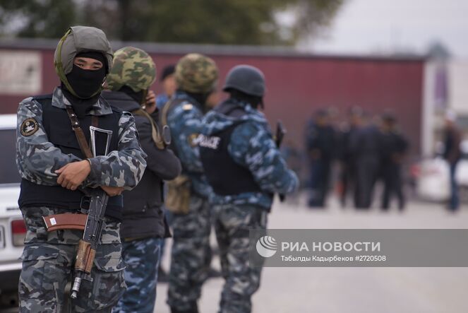 Сотрудники правоохранительных органов Киргизии стоят в оцеплении неподалеку от участка, где скрывается беглый заключенный, во время операции по поиску исламистов, приговоренных к пожизненному заключению за терроризм и бежавших из СИЗО. Место: Киргизия, Бишкек. Автор: Табылды Кадырбеков/РИА Новости. Операция правоохранительных органов Киргизии в Бишкеке