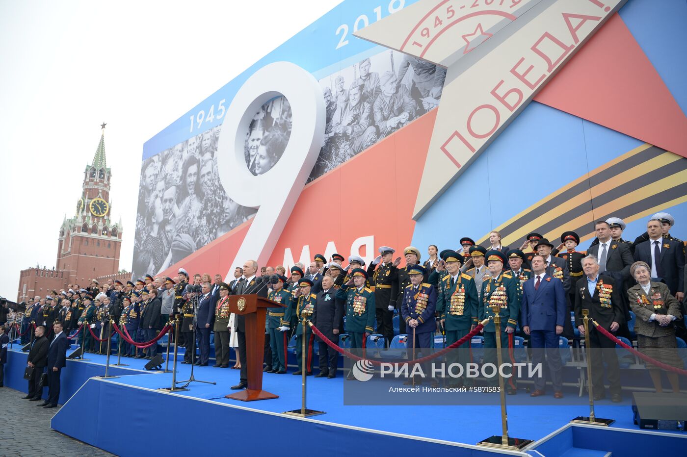 9 мая 2019. Президент РФ - верховный главнокомандующий вооружёнными силами РФ Владимир Путин выступает перед началом военного парада в ознаменование 74-й годовщины Победы в Великой Отечественной войне 1941–1945 годов на Красной площади в Москве. Третий справа - председатель правительства РФ Дмитрий Медведев. Место: Россия, Москва. Автор: Алексей Никольский/РИА Новости. Президент РФ В. Путин и премьер-министр РФ Д. Медведев на военном параде в честь 74-й годовщины Победы в ВОВ