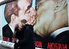 Молодые люди у фрагмента Берлинской стены (East-Side Gallery) на Мюленштрассе с произведением Дмитрия Врубеля "Господи! Помоги мне выжить среди этой смертной любви" или "Братский поцелуй" (поцелуй Брежнева и Хонеккера). В Берлине проходят мероприятия по случаю 30-летней годовщины падения Берлинской стены, ознаменовавшего воссоединение населения ФРГ и ГДР. Место: Германия, Берлин. Автор: Алексей Витвицкий/РИА Новости. Мероприятия по случаю 30-летней годовщины падения Берлинской стены