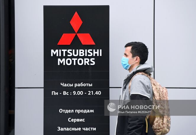Прохожий в медицинской маске у автомобильного салона Mitsubishi Motors в Москве. Автомобильные салоны возобновили работу после карантина в Москве с 1-го июня. Место: Россия, Москва. Автор: Илья Питалев/РИА Новости. Открытие автомобильных салонов после карантина в Москве