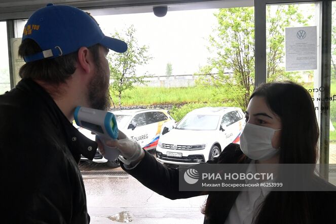 Сотрудница автосалона "АвтоСпецЦентр" в Москве измеряет температуру тела у посетителя. Автомобильные салоны возобновили работу после карантина в Москве с 1-го июня. Место: Россия, Москва. Автор: Михаил Воскресенский/РИА Новости. Открытие автомобильных салонов после карантина в Москве