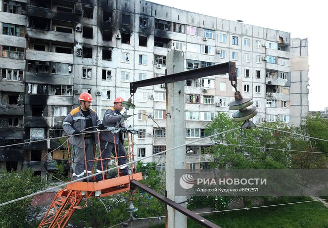 Электромонтеры восстанавливают электроснабжение на одной из улиц в Мариуполе. Место: Донецкая народная республика, Мариуполь. Автор: Алексей Куденко/РИА Новости. НЕДЕЛЯ В ФОТОГРАФИЯХ