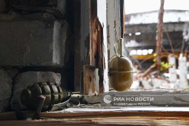 Гранаты на окне одного из разрушенных зданий на территории комбината "Азовсталь" в Мариуполе. В настоящее время на территории комбината саперы батальона "Восток" Народной милиции ДНР проводят разминирование и подрыв неразорвавшихся снарядов. Место: Донецкая народная республика, Мариуполь. Автор: Алексей Куденко/РИА Новости. Разминирование территории комбината "Азовсталь" в Мариуполе